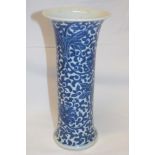 A 19th century Chinese cylindrical vase with blue and white painted floral decoration 10" high