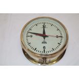 A Polish nautical wall clock with painted circular dial in brass cylindrical case