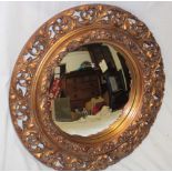 A convex circular wall mirror in ornate gilt decorated circular frame,