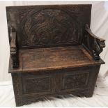 A good quality carved oak rectangular monk's bench with tilting carved top and griffin masked