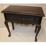 A late Victorian carved oak rectangular side table with a single drawer in the frieze on cabriole