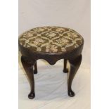 A 1920's walnut oval dressing stool with floral tapestry upholstered seat on cabriole legs