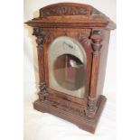 An Edwardian carved oak bracket clock case only with silvered part arched dial