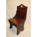 A 19th century oak ecclesiastical-style chair with panelled arched back,