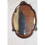A Victorian oval wall mirror in mahogany frame with attached sconce brackets,