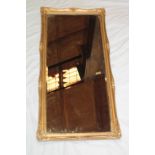 A bevelled rectangular wall mirror in ornate gilt frame,