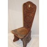 An old carved oak spinning chair with decorated back and carved seat on standard supports