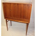 A 1950's/1960's Danish teak cocktail bar/cabinet with mirror and formica-lined interior enclosed by