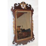 A 19th century bevelled rectangular wall mirror in mahogany and gilt decorated scroll frame with