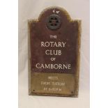 An old bronze arched sign "The Rotary Club of Camborne" with applied Rotary badge on oak wall