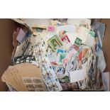 A box containing various World stamps on/off paper