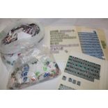 A box containing a selection of GB regional stamps, stamps on/off paper etc.