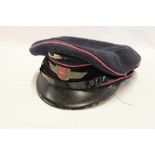 A Continental blue cloth Fire Services peaked cap with enamelled badge