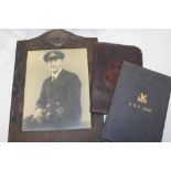 A leather covered photo frame with raised Royal Navy badge and inset Officer's photograph,