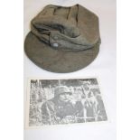A Second War German Khaki military peaked cap with pebble-dashed buttons and a Second War postcard