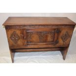 A reproduction 17th century oak rectangular side cupboard enclosed by a central decorated panelled