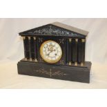 A Victorian mantel clock with part visible escapement in polished black slate pavilion-style case