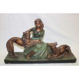 A 1930's Art Deco painted plaster figure of a seated female with two Alsatian dogs,