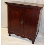 An Edwardian mahogany sheet music cupboard with fitted interior enclosed by two panelled doors on