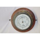 An aneroid barometer by John Barker & Co Kensington with ceramic dial in brass circular case and