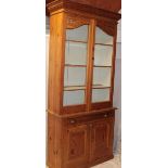 A 19th century polished pitch pine bookcase with a single drawer in the frieze and cupboard