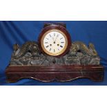 An impressive Cornish serpentine mantel clock with circular enamel dial,