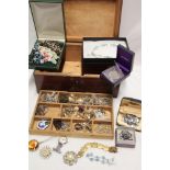 A mahogany jewellery box containing a quantity of costume jewellery including necklaces, brooches,