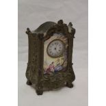 A French mantel clock with decorated circular dial within porcelain panel depicting a woodland