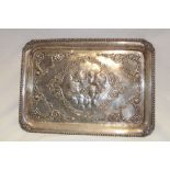 An Edward VII silver rectangular tray decorated in relief with angels and scrolls,