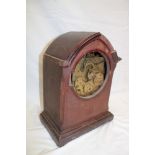 An Edwardian mantel clock with brass movement (minus dial) in inlaid mahogany Gothic arched case