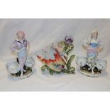 A pair of German porcelain figures of a male and female with floral baskets,