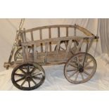 An old wooden four wheel dog cart with folding centre shaft,