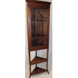 An Edwardian inlaid mahogany corner display cabinet with shelves enclosed by a single glazed door