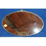 A 1930/40s bevelled oval wall mirror in chromium plated mounts,