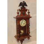 A Vienna-style wall clock with decorated circular dial in walnut rectangular case with column