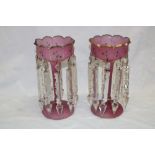 A pair of Victorian pink tinted glass table lustres with gilt decoration and lozenge droplets,