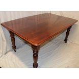 A Victorian figured mahogany rectangular dining table on turned tapered legs with casters,