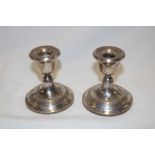 A pair of silver squat-shaped candlesticks with circular bases,