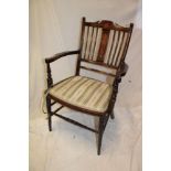 A late Victorian inlaid mahogany open arm occasional chair with upholstered seat on turned legs and