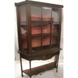 Edwardian mahogany display cabinet with shelves enclosed by two canted glazed side doors on
