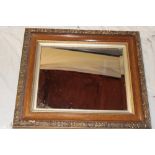 A bevelled rectangular wall mirror in ornate gilt and stained frame,