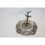 A small silver rustic ring stand on stylized circular base,