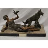 A Continental Art Deco bronzed spelter figure of a reclining female with bird and Alsatian dog on