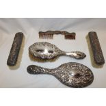 A pair of silver backed clothes brushes with raised decoration,