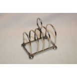 A small silver four-section toast rack with loop handle,