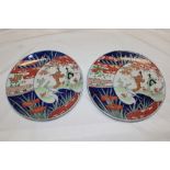A pair of Japanese Imari pottery circular chargers with female, bird and landscape decoration,