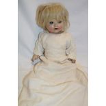 An old composition and porcelain headed doll with jointed body,