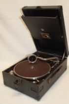 An old portable gramophone by His Master's Voice in black fibre case