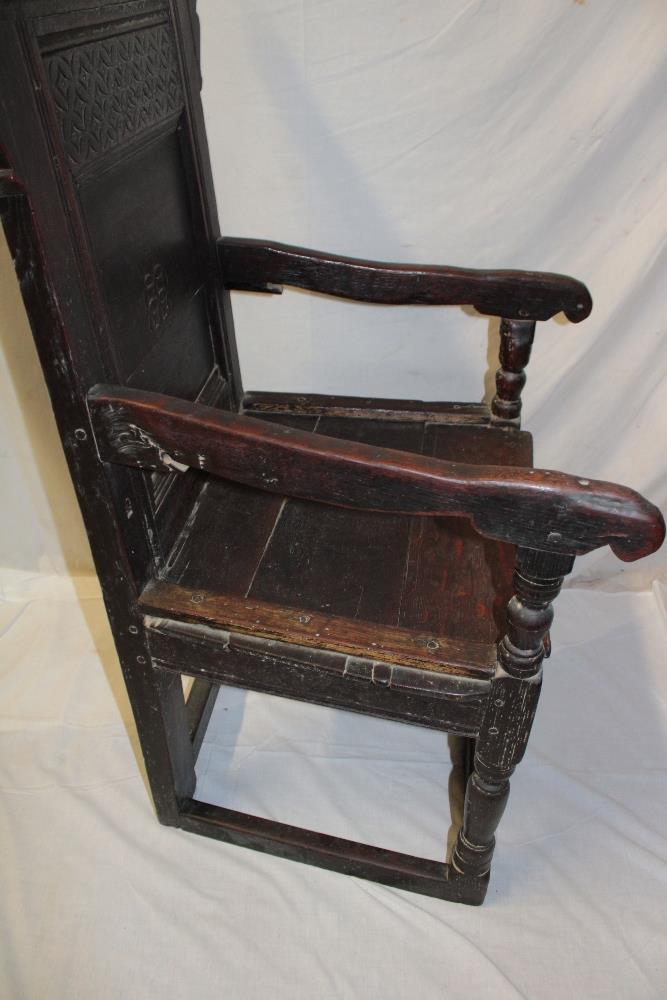 A 17th century carved oak carver armchair with arched panelled back and planked seat on turned - Image 4 of 5