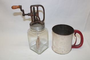 A vintage enamel sieve with rotating base and an old glass mixing bottle with wooden paddle and a
